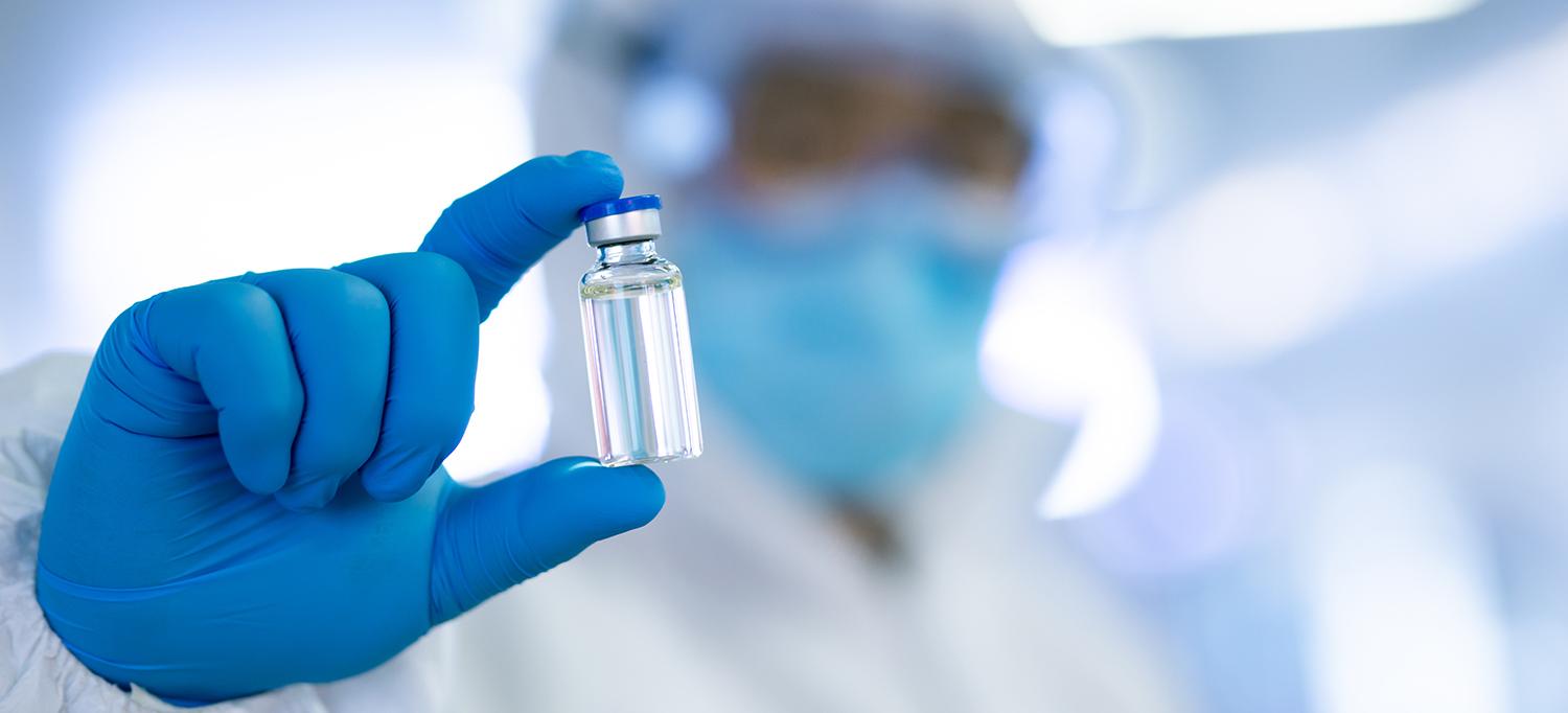 Doctor in Personal Protective Equipment Holds Medical Vial