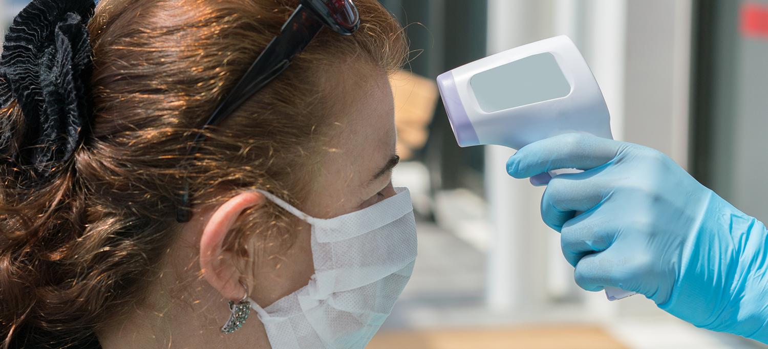 Care Provider Checks Person’s Temperature with No Touch Thermometer